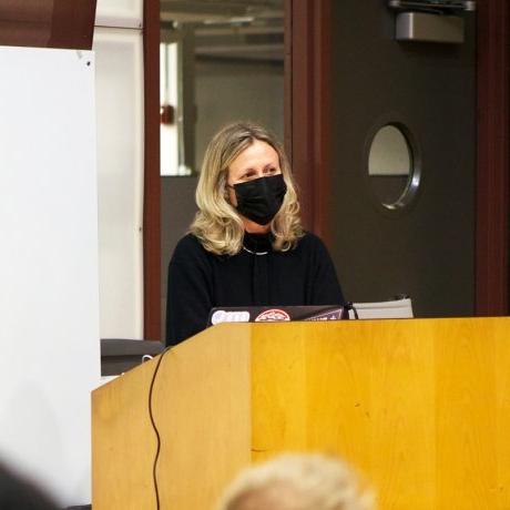 A woman presenting with a mask on. 